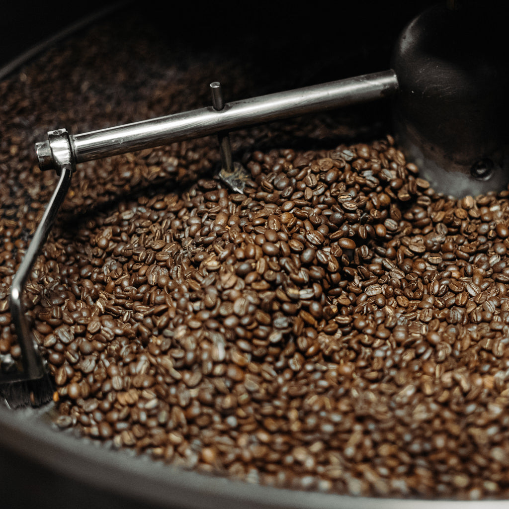 Freshly roasted coffee beans cooling in a roaster at Cottonwood Coffee, highlighting the artisanal roasting process and dedication to quality.
