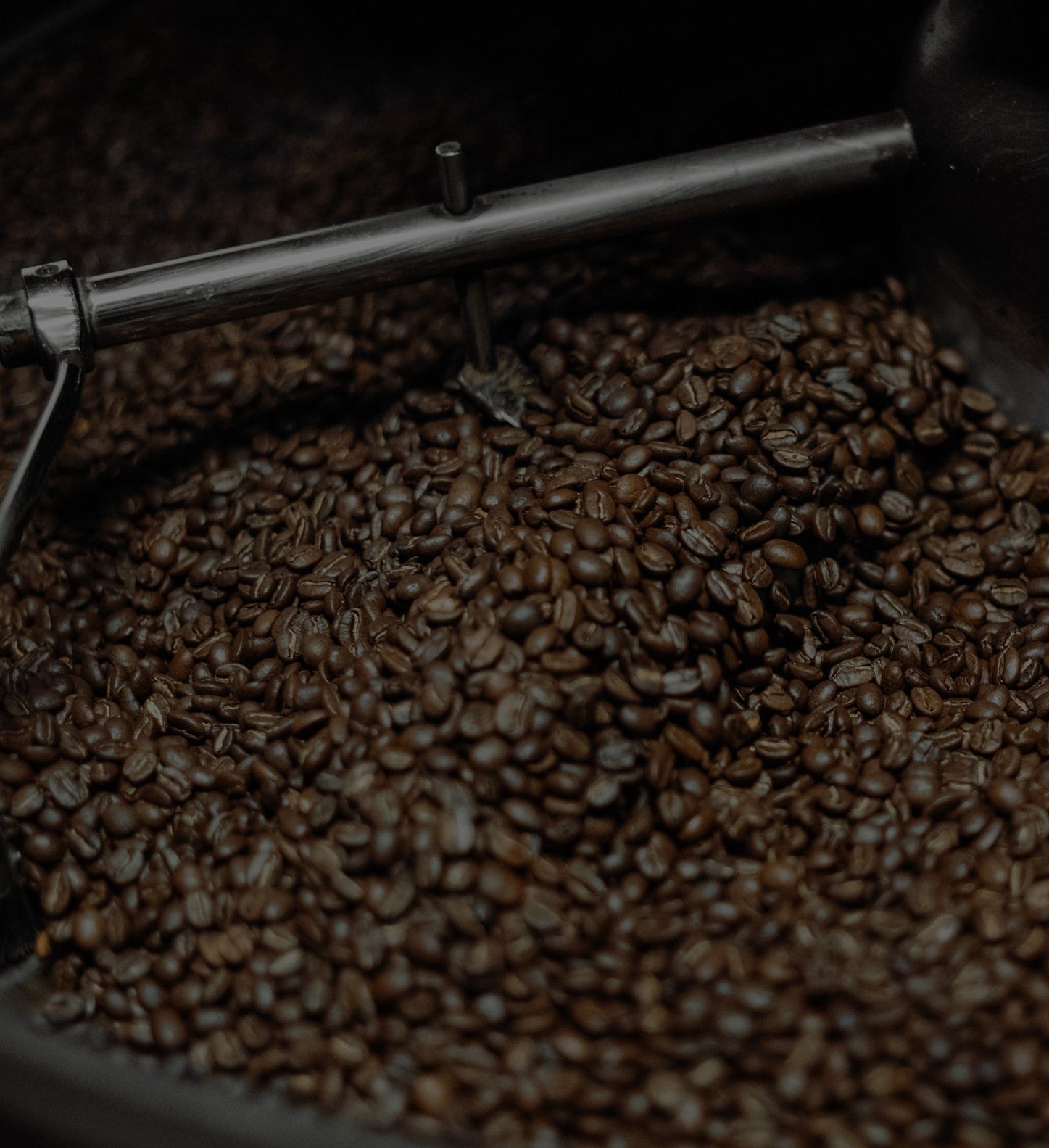 Freshly roasted coffee beans in a roaster at Cottonwood Coffee, highlighting the artisanal roasting process.